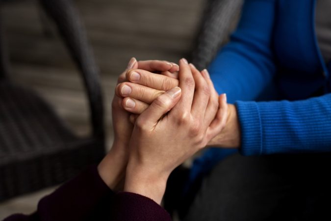 A male counsellor offering empathy to a distressed woman during a group session for mental health treatment in Mumbai.