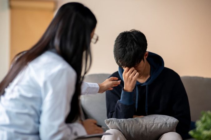 A professional female counsellor Mumbai offering support to a young man during a private therapy session.